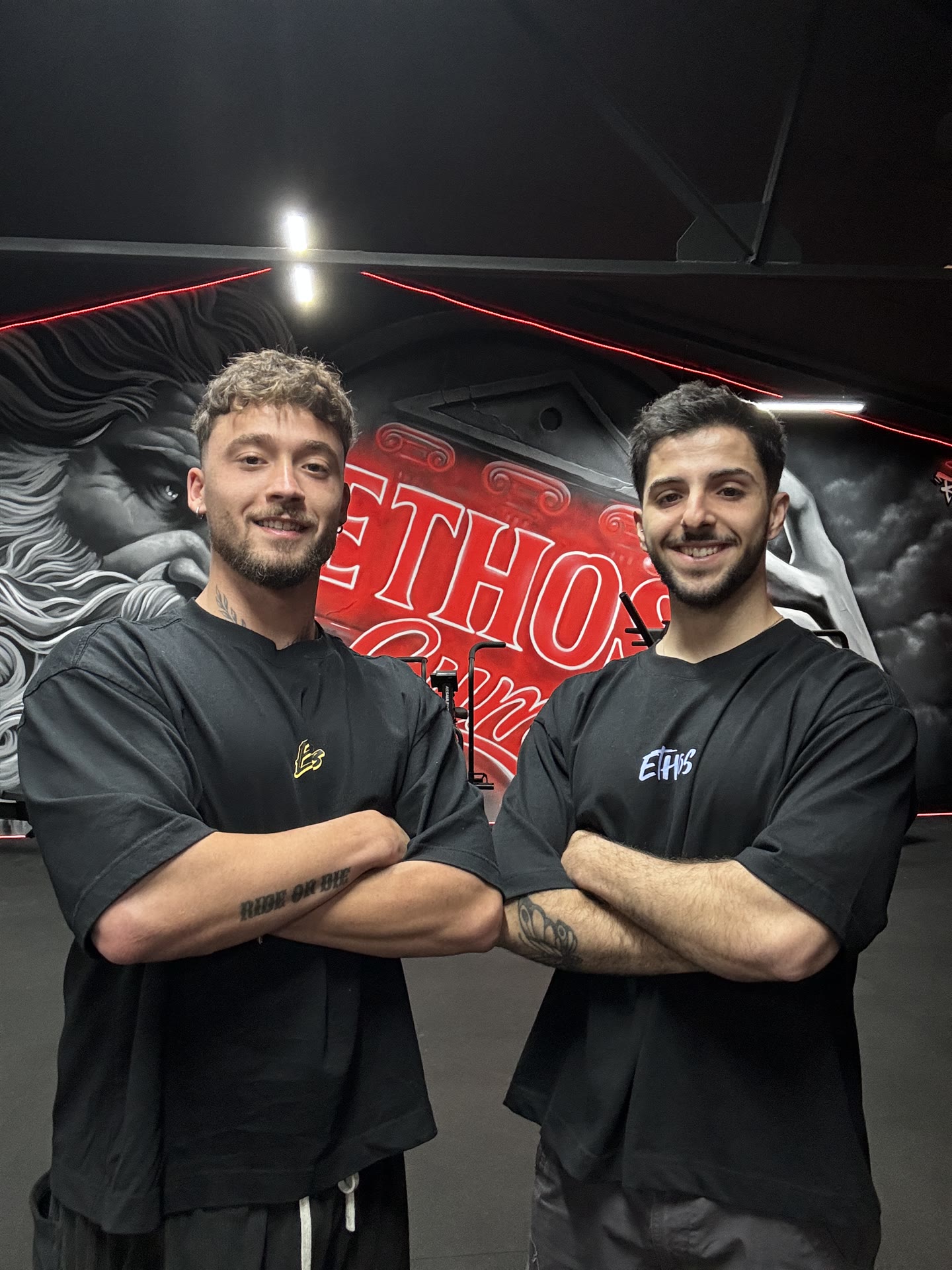 Los entrenadores de Ethos Fitness delante del mural del centro